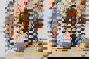 Mensen lachen achter een laptop.