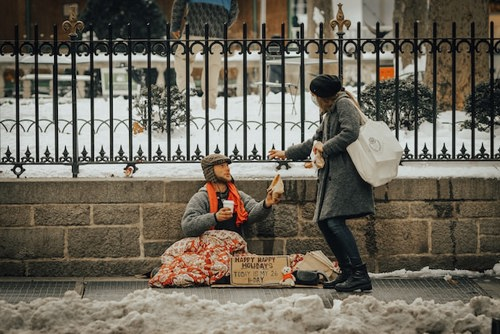 Altruïstisch gedrag: een vrouw die een dakloze man helpt