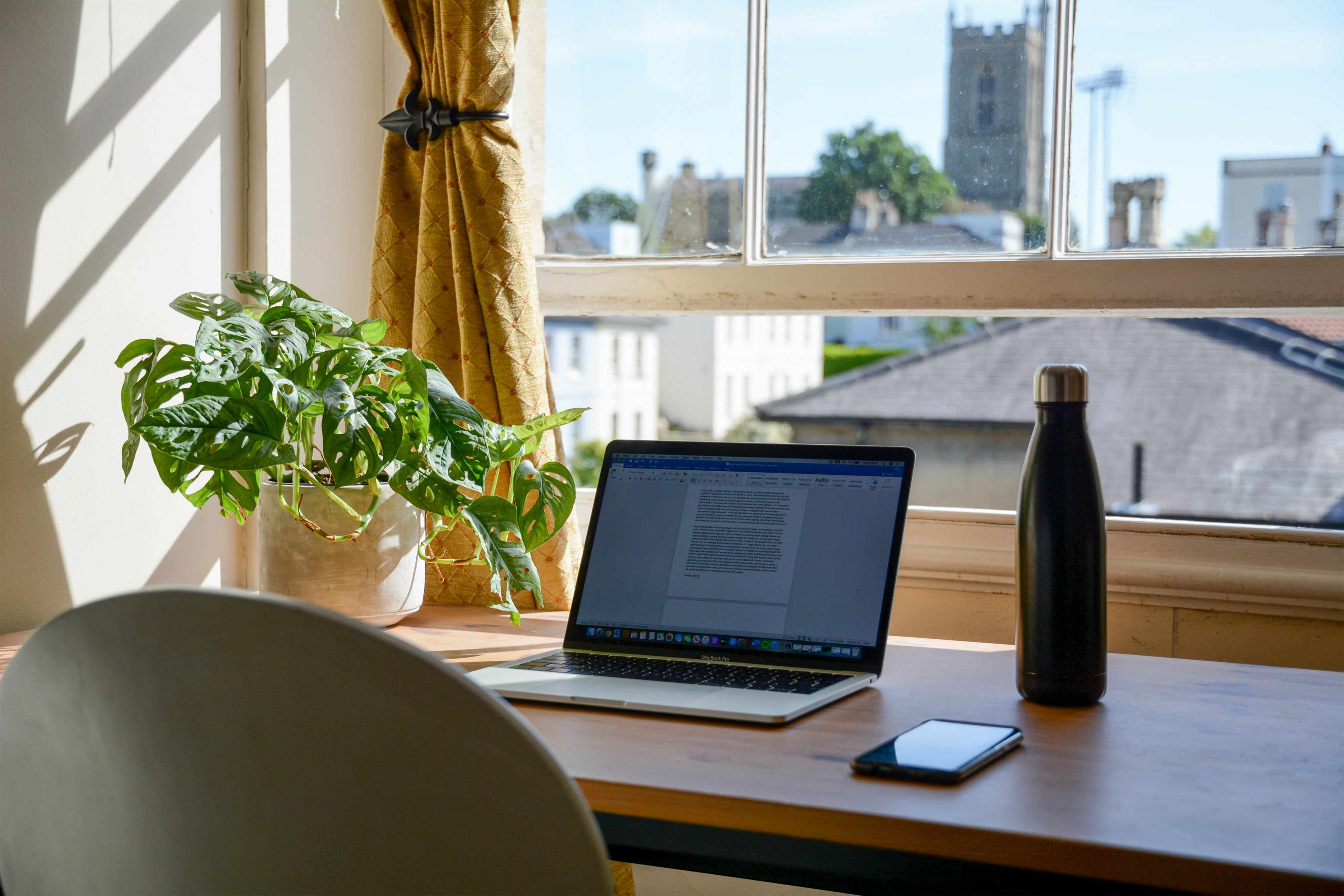 Thuiskantoor laptop op bureau voor raam